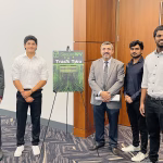 Students standing with Dr. Al-Sinayyid an an easel with a poster at the Secure WV conference