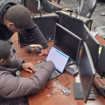 Photo of two CIC students working on a laptop in a computer lab