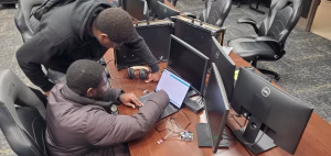 Photo of two CIC students working on a laptop in a computer lab