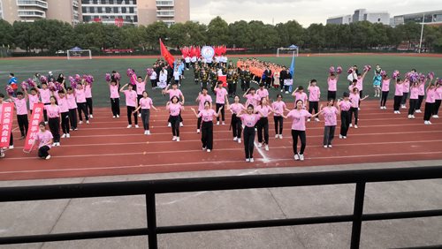 Group of NBUT cheer students in formation on field during a performance.
