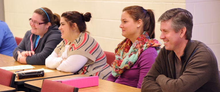 Photo of students at a table participating in a discussion